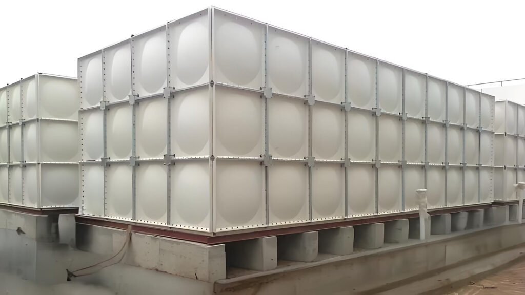 FRP modular water tank with bolted panels on concrete base.
